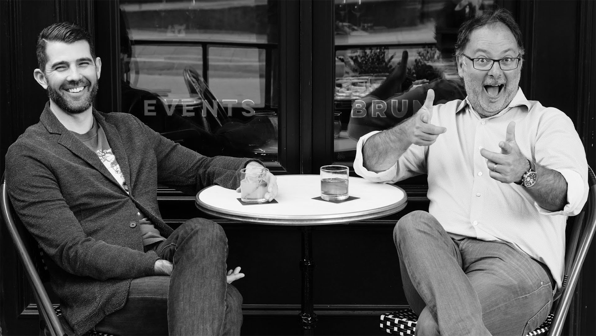 Jerrett Young and Jason Cassis sitting outside a cafe drinking coffee